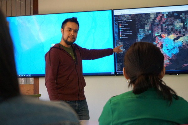 Man demonstrating Esri mapping technology on a wide screen Man demonstrating Esri mapping technology on a wide screen