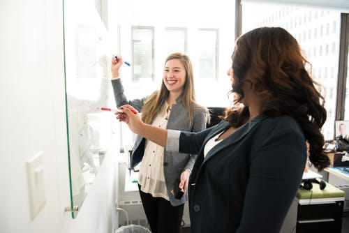 Women writing on a white board Women writing on a white board