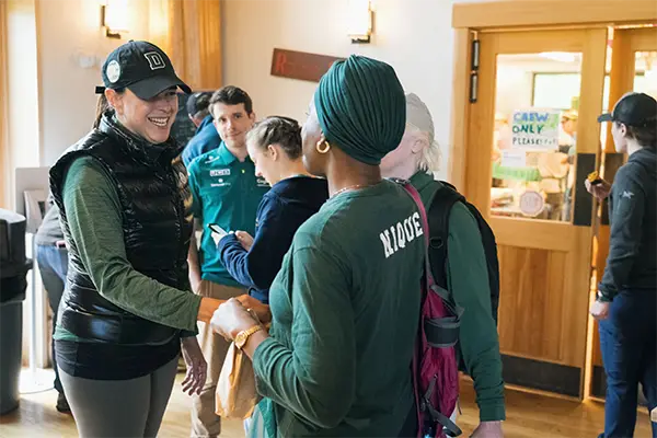 Women in Dartmouth gear shaking hands