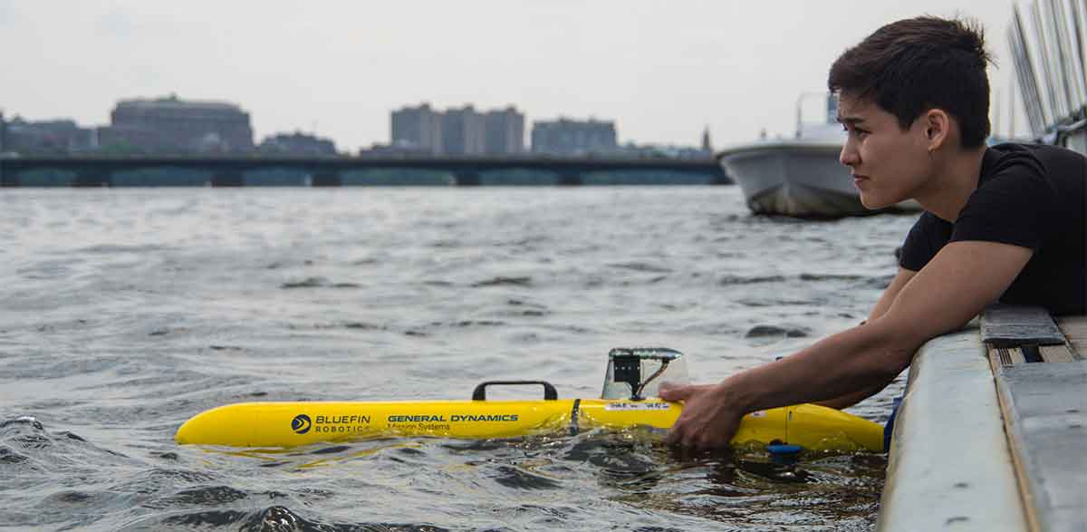 GDMS-bluefin-robot-woman-stem Woman placing bluefin robot in the water off the site of a ship.