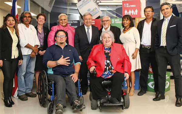 Secretary General surrounded by diverse people with 2 wheelchair users in front