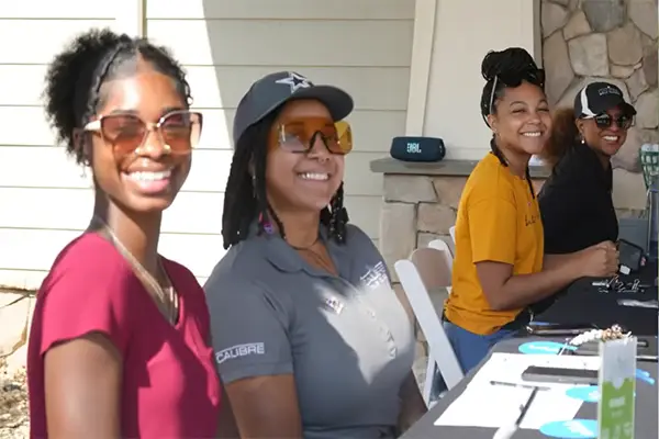African American women smiling at an outdoor table