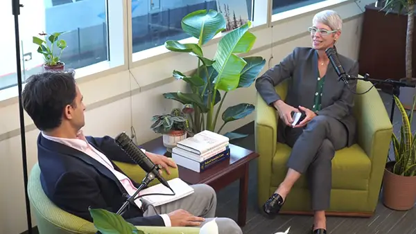 woman and man sitting in comfortable charis speaking into microphones