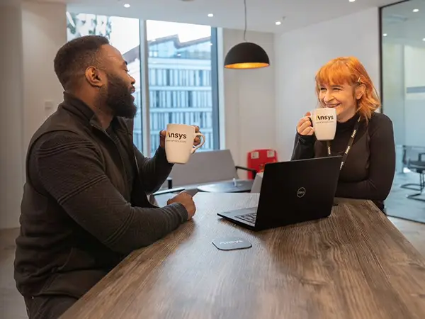 Man and woman having a coffee duscussion over a laptop