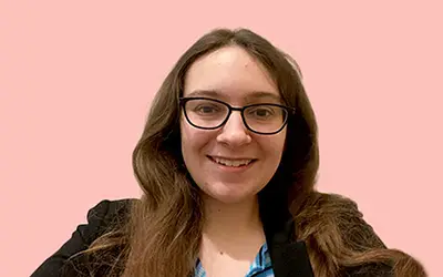 woman in suit jacket and glasses smiling