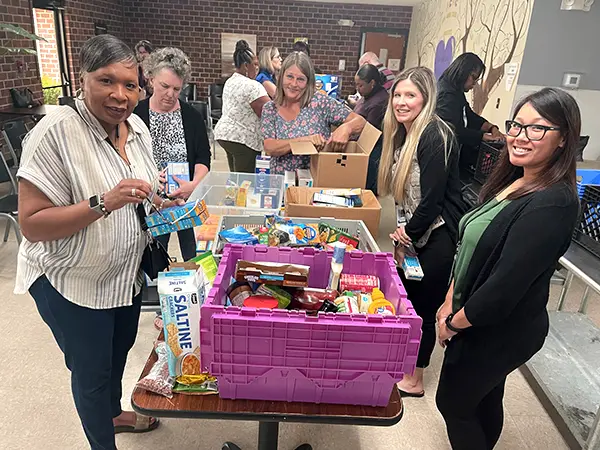 women packing food in bins at a food collection